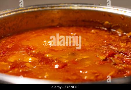 Gros plan Homecooking. Préparation de sauce bolognaise maison. Préparation de sauce tomate. poix de mire sautée. Cuisson des tomates. Brunissement du bœuf haché. Banque D'Images