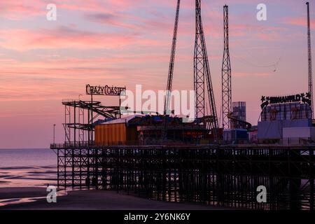 Un coucher de soleil tranquille jette des teintes douces sur une jetée vide, évoquant une fin de journée sereine. Banque D'Images