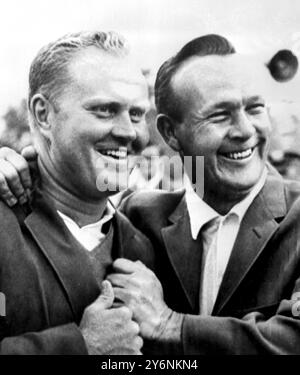 Augusta, Géorgie : le golfeur Arnold Palmer (à droite), champion en titre, aide le champion New Masters Jack Nicklaus dans son manteau vert, le symbole traditionnel du Championnat de Golf Masters, ici hier. Nicklaus a gagné par neuf trokes, établissant un nouveau record de parcours de 271 pour 72 trous. 12 avril 1965 Banque D'Images