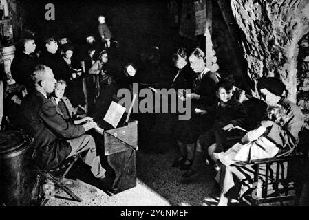 Une ville souterraine du sud de l'Angleterre imperméable aux bombes volantes Un service de chant d'hymne en cours dans l'une des grottes profondes d'une ville du sud de l'Angleterre où les gens dorment profondément malgré les bombes volantes août 1944 ©2004 Topfoto Banque D'Images