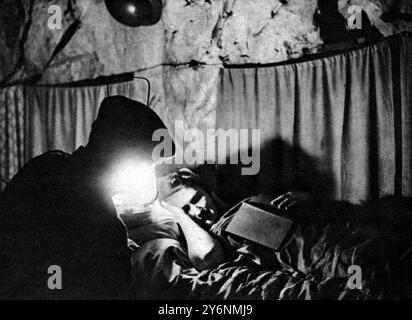 Une ville souterraine dans le sud de l'Angleterre imperméable aux bombes volantes les habitants de la grotte se sont installés pour la nuit, et un gardien d'abri fait son tour pour voir que ses charges sont confortables août 1944 ©2004 Topfoto Banque D'Images