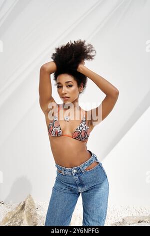 Une jeune femme afro-américaine à la mode prend une pose confiante dans une tenue élégante. Banque D'Images