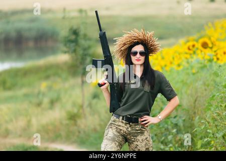 Soldat féminin en uniforme militaire. Une fille en uniforme militaire avec une arme. Femme ukrainienne dans une couronne. Banque D'Images