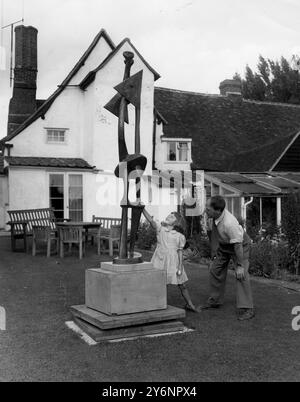 Henry Moore, sculpteur dans sa maison de campagne -'Hogland ' Perry jardin, beaucoup Hadaam, Herts en arrière-plan est le 15 siècle chalet où il vit. Avec le sculpteur est Marie, sa fille de 6 ans 1952 Banque D'Images