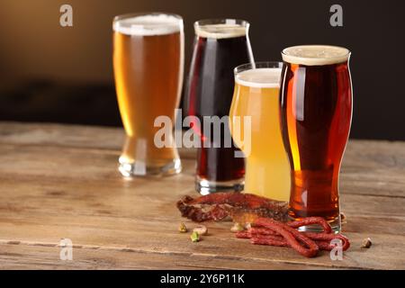 Verres avec différents types de bière et de collations sur la table en bois Banque D'Images