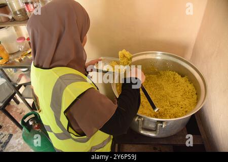 Tripoli, Liban. 26 septembre 2024. Une femme prépare de la nourriture pour les personnes déplacées du Sud-Liban à Tripoli, Liban, le 26 septembre 2024. Le ministre libanais de l'environnement, Nasser Yassine, a déclaré mercredi que les bombardements israéliens avaient déplacé plus de 150 000 résidents au cours des dernières 72 heures. La forte escalade a suscité des inquiétudes quant à un conflit potentiel à grande échelle entre Israël et le Liban, avec la crainte que d'autres puissances régionales ne soient également aspirées. Crédit : Khaled Habashiti/Xinhua/Alamy Live News Banque D'Images