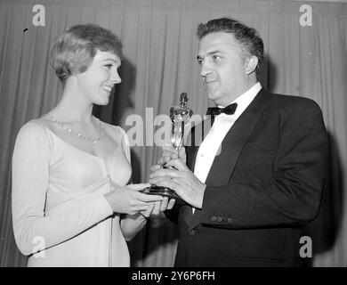 L'actrice chanteuse Julie Andrews présente au réalisateur italien Federico Fellini son Oscar pour son film 8 1/2 16 avril 1964 Banque D'Images