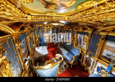 Nuremberg, Allemagne. 26 septembre 2024. Les restaurateurs Luisa Lehmann et Lars von Steinmetz travaillent dans le chariot de l'ancien train royal de la cour bavaroise au DB Museum dans le cadre d'un projet de restauration. Le roi Louis II de Bavière est connu pour ses magnifiques palais. Mais le monarque aimait aussi la pompe en voyageant - et a fait reconstruire le train de la cour bavaroise dans le style baroque français. Les calèches de salon et les calèches de terrasse sont toujours conservées au DB Museum Nuremberg et sont actuellement en cours de restauration. Crédit : Daniel Karmann/dpa/Alamy Live News Banque D'Images