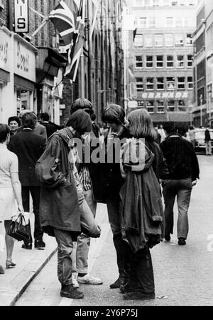 Le centre de la mode de Londres pour les jeunes ensembles - figures familières dans ce qui est probablement la rue la plus connue sinon la plus populaire de Londres... Les jeunes aux cheveux longs parlent de Carnaby Street, la Mecque des mod fashion de la capitale anglaise, du mini-est des minis aux derniers styles de vestes et de pantalons pour hommes, peuvent être achetés à Carnaby Street, le siège de la mode des jeunes le 20 juillet 1967 Banque D'Images