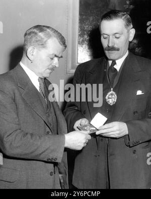 Sir Frank Whittle (à gauche) , le pionnier du moteur à réaction , regarde la médaille d'or Churchill qui lui sera remise lors d'une cérémonie à Londres ce soir . La médaille est décernée par la Société des ingénieurs , dont M. RS Barber (à droite) est président . Sir Frank , 45 ans , sera le premier récipiendaire du prix qui sera décerné tous les deux ans pour le développement le plus remarquable en ingénierie . Le prix a été approuvé par M. Winston Chutchill , qui est membre honoraire de la Société . 6 octobre 1952 Banque D'Images