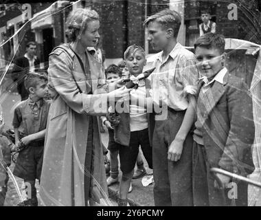 Les enfants de Mitre St , Waterloo , Londres , ont décidé qu'un ajout agréable à la rue serait un spectacle de Punch et Judy , qu'ils ont fait à partir de morceaux de ferraille et de boîtes orange . Les cinq enfants qui ont réalisé et organisé le spectacle sont Fred Wilson , Will Webb , qui fait aussi des commentaires , Dave Eason , Raymond Jordan et Will Bridges . L'image montre Ursula Jeans, scène et star d'écran parmi le public enfantin du spectacle Punch et Judy . 11 août 1950 Banque D'Images