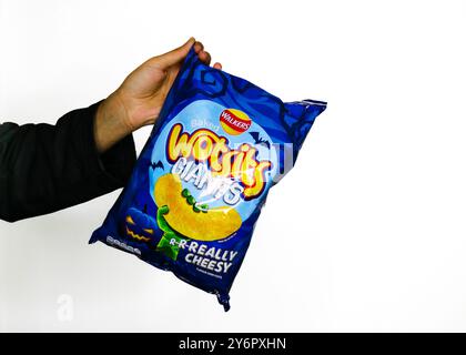Londres, Angleterre, septembre 26 2024 : bras attrapant un sac de Wotsits Halloween Walkers avec un fond blanc avec la marque pour Halloween 2024 Banque D'Images