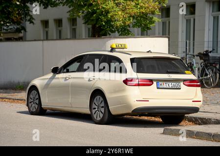 Munich, Bavière, Allemagne - 23 septembre 2024 : un taxi à Munich garé sur le bord de la route avec un panneau jaune typique de taxi sur le toit *** Ein Taxi in München, das am Straßenrand parkt, mit einem typischen gelben Taxi-Schild auf dem Dach Banque D'Images