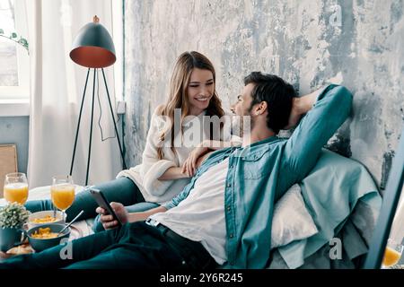 Pas de soucis. Beau jeune couple prenant le petit déjeuner tout en passant du temps au lit à la maison Banque D'Images