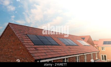 Le toit d'une rangée de maisons neuves sur un chantier de construction avec toit intégré ou dans le toit panneaux solaires pour l'énergie bon marché et durable dans un éco f Banque D'Images