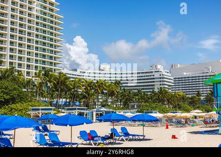 Parasols bleus et hôtels de luxe le long de Miami Beach par jour ensoleillé au bord de l'océan Atlantique. Miami Beach. ÉTATS-UNIS. Banque D'Images