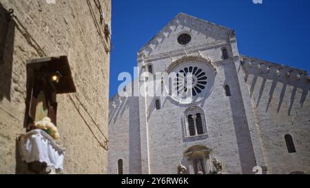 Façade élégante de la basilique historique de saint-nicolas à bari, en italie, démontrant des détails architecturaux complexes contre un ciel bleu clair en th Banque D'Images