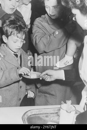 Kingston upon Hull, Yorkshire : le jeune Harry semble méfiant du sucre offert à lui dans une clinique ici hier, mais mère sait mieux, car c'était la scène où la première vaccination de masse par la bouche contre la polio a eu lieu à Kingston-upon-Hull, Yorkshire.100 000 adultes, enfants et bébés ont été vaccinés ici hier. Les parents et les enfants ont sucé des morceaux de sucre et les bébés ont nourri du sirop contenant le vaccin Sabin qui est administré en quinze secondes à plat. 18 OCTOBRE 1961 Banque D'Images