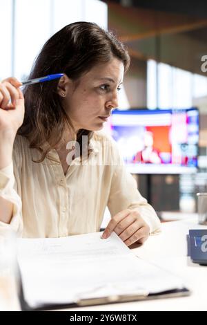 Leader féminin signant des documents de gestion juridique et des contrats, lui donnant l'autorisation pour les contrats de licence et les demandes de congé des employés. Le PDG s'occupe de la paperasserie au bureau. Banque D'Images