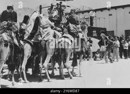 LAWRENCE AVEC DES CAVALIERS DE CHAMEAU Aqaba, Jordanie : L'acteur Peter O'Toole, jouant le rôle-titre dans la production Horizon Pictures de Lawrence d'Arabie, dirige un groupe de cavaliers de chameau bédouins à travers le camp d'unité à Aqaba lors d'une visite à la compagnie de cinéma par le roi de Jordanie, le roi Hussein ici récemment. 24 AVRIL 1961 Banque D'Images