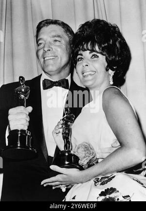 18 AVRIL 1961 BURT LANCASTER ET ELIZABETH TAYLOR REMPORTENT LES OSCARS DU MEILLEUR ACTEUR ET DES PRIX DE LA MEILLEURE ACTRICE AUX ACADEMY AWARDS POUR LEURS RÔLES DANS 'ELMER GANTRY' ET 'BUTTERFIELD EIGHT'. HOLLYWOOD, CALIFORNIE, ÉTATS-UNIS. Banque D'Images