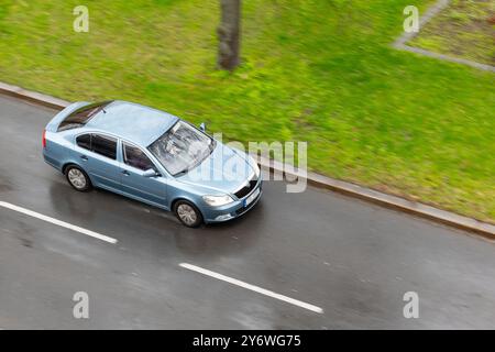 OSTRAVA, RÉPUBLIQUE TCHÈQUE - 23 MARS 2024 : Blue Skoda Octavia II liftback car sous la pluie avec effet de flou de mouvement Banque D'Images