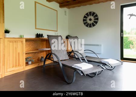 Deux chaises longues dans la salle de détente, bains de soleil. Deux tours blanches sur des chaises longues. Banque D'Images