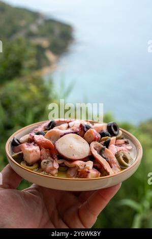 Savoureux antipasti salade ou plat de fruits de mer, poulpe grillé style ligure avec olives vertes et noires servies dans le restaurant italien Banque D'Images