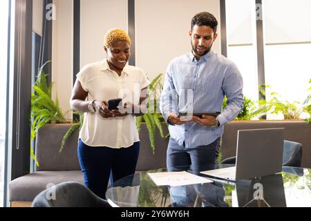 Collaboration dans un bureau moderne, collègues d'affaires utilisant smartphone et tablette Banque D'Images