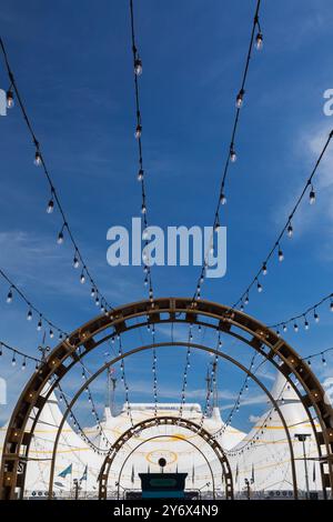 Le couloir de l'entrée principale arbore des guirlandes lumineuses de style industriel menant à l'installation de la grande tente « Kurios » du Cirque du Soleil. Banque D'Images