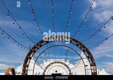 Le couloir de l'entrée principale arbore des guirlandes lumineuses de style industriel menant à l'installation de la grande tente « Kurios » du Cirque du Soleil. Banque D'Images