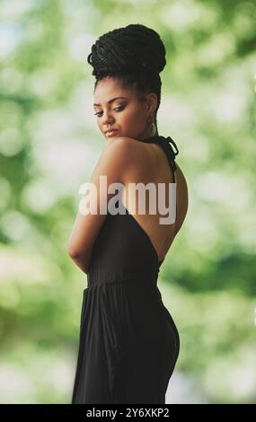 Femme fière, mode et africaine dans le jardin pour le patrimoine, la culture ou la tradition avec des tresses. Tenue féminine, modèle confiant ou élégant dans la nature pour Banque D'Images