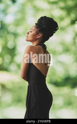 Calme, mode et femme africaine dans le jardin pour le patrimoine, la culture ou la tradition avec des dreadlocks. Tenue naturelle, modèle confiant ou élégant dans la nature pour Banque D'Images