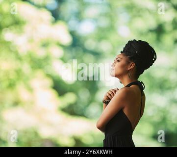 Pensée, mode et femme africaine dans le jardin pour le patrimoine, la culture ou la tradition avec des tresses. Idées de tenue, modèle confiant ou élégant dans la nature pour Banque D'Images