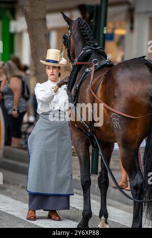 Femme vêtue d'un costume d'époque et d'un chapeau avec son cheval dans les rues de Fuengirola lors de la célébration de la Día del Caballo (jour du cheval). Banque D'Images