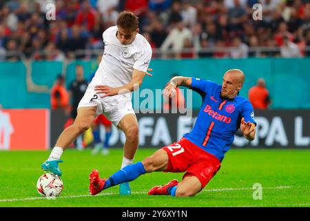 Bucarest, Roumanie. 26 septembre 2024. Adam Marhiev (l) du FK RFS affronte Vlad Chiriches du FCSB lors d'un match de l'UEFA Europa League entre la FCSB et le FK RFS à Bucarest, Roumanie, le 26 septembre 2024. Crédit : Cristian Cristel/Xinhua/Alamy Live News Banque D'Images