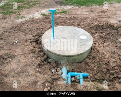 La fosse septique en béton est installée derrière les toilettes de la maison de campagne, vue de face avec l'espace copie. Banque D'Images