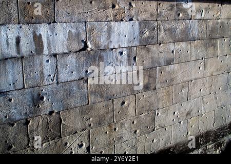 Le mur de pierre historique près de la rivière Spree montre des trous de balles visibles, vestiges de la seconde Guerre mondiale à Berlin, en Allemagne. Banque D'Images