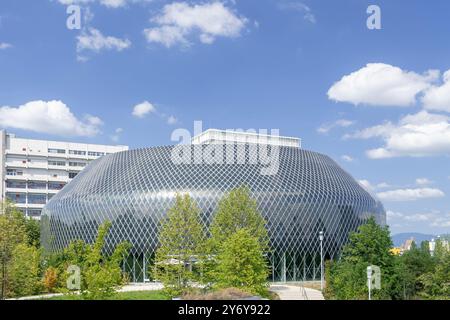 Vue sur le Pavillon Novartis, un complexe de bâtiments circulaires construit sur un campus universitaire. La façade est composée de milliers de cellules solaires. Banque D'Images