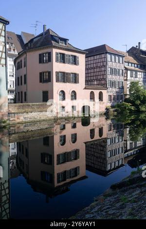 Strasbourg - vue sur le quartier Tanner avec ses bâtiments à colombages colorés et la rivière Ill et ses reflets sur l'eau. Banque D'Images