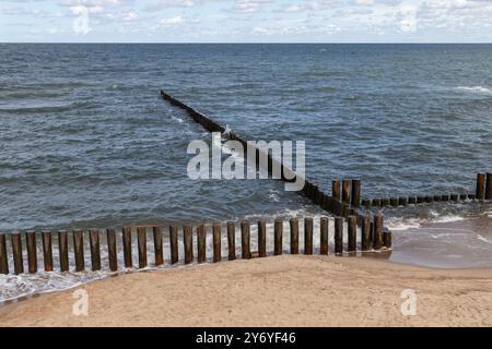 Paysage balnéaire avec eau du rivage et brise-lames en bois, côte de la mer Baltique. Zelenogradsk, oblast de Kaliningrad, Russie Banque D'Images