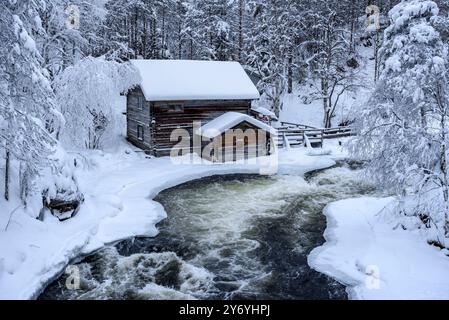 Ancien moulin de Myllykoski, couvert de neige en hiver, à côté des rapides de la rivière Kitkajoki dans le parc national d'Oulanka (Juuma Kuusamo Laponie Finlande) Banque D'Images