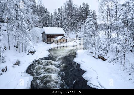 Ancien moulin de Myllykoski, couvert de neige en hiver, à côté des rapides de la rivière Kitkajoki dans le parc national d'Oulanka (Juuma Kuusamo Laponie Finlande) Banque D'Images