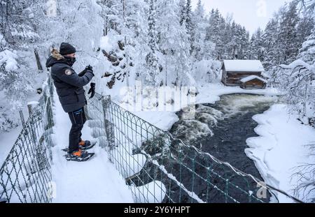 Ancien moulin de Myllykoski, couvert de neige en hiver, à côté des rapides de la rivière Kitkajoki dans le parc national d'Oulanka (Juuma Kuusamo Laponie Finlande) Banque D'Images