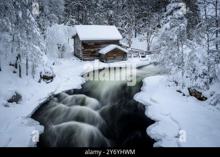 Ancien moulin de Myllykoski, couvert de neige en hiver, à côté des rapides de la rivière Kitkajoki dans le parc national d'Oulanka (Juuma Kuusamo Laponie Finlande) Banque D'Images