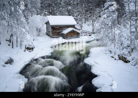 Ancien moulin de Myllykoski, couvert de neige en hiver, à côté des rapides de la rivière Kitkajoki dans le parc national d'Oulanka (Juuma Kuusamo Laponie Finlande) Banque D'Images
