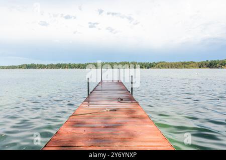 Quai en bois s'étendant dans le lac sous le ciel bleu Banque D'Images