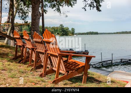 Chaises Adirondack face au lac au rivage Banque D'Images