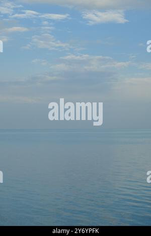 scène sereine où l'eau rencontre le ciel et l'horizon se fond Banque D'Images