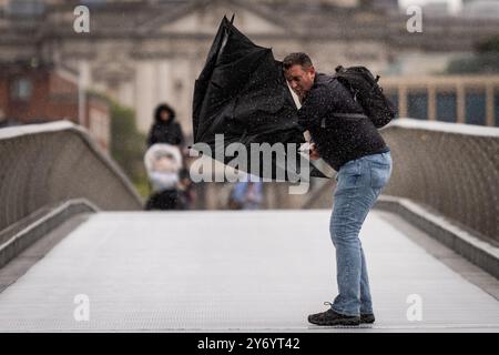 Des personnes portant des parapluies se battent sous la pluie sur Millennium Bridge, à Londres, après que des parties de l'Angleterre aient été battues par de fortes pluies et des inondations dans les premières heures de vendredi. Date de la photo : vendredi 27 septembre 2024. Banque D'Images